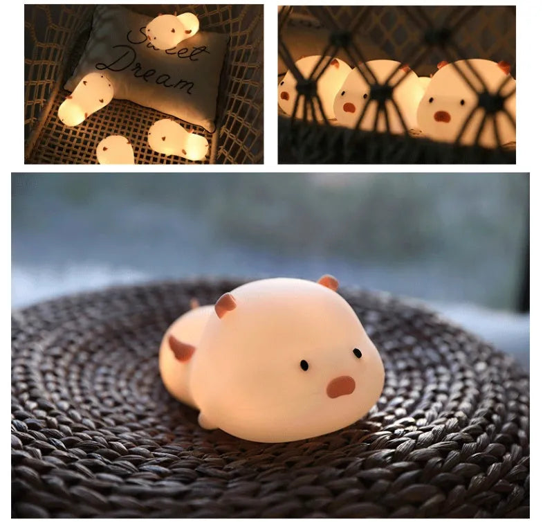 Cute pig silicone night light in Pink with sleeping face design on a wooden table