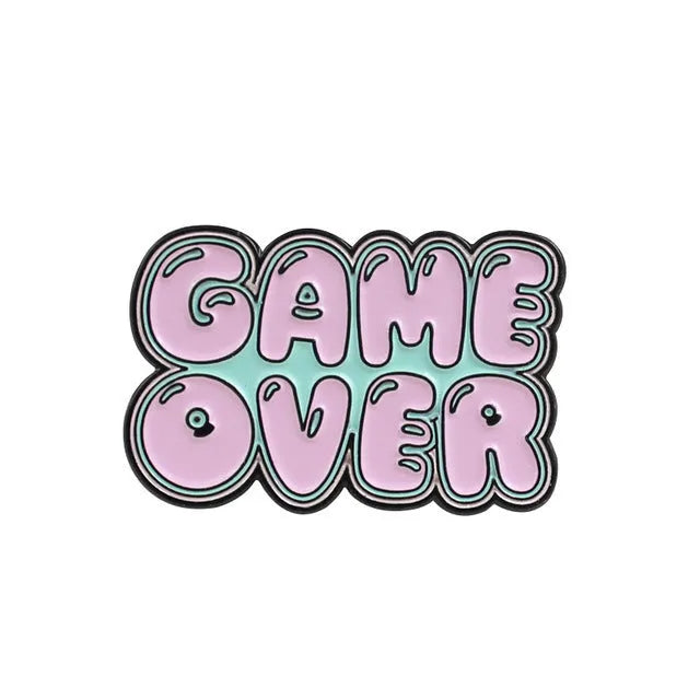 Stereo game console badge pin made from alloy metal on a bag, showing three colour variant options.