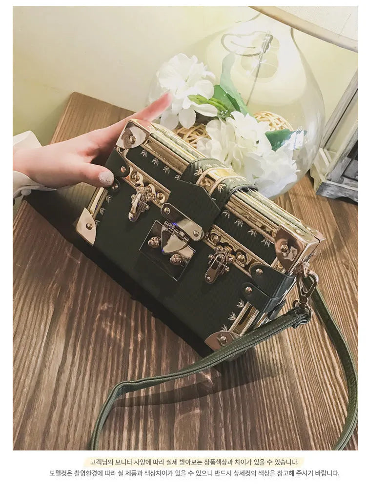 Women's hard frame shoulder bag in black or green with single adjustable strap and flap closure