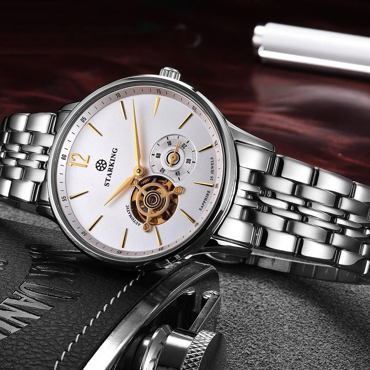 Automatic mechanical men's watch with brown leather strap and stainless steel case showing hollow three-needle dial design