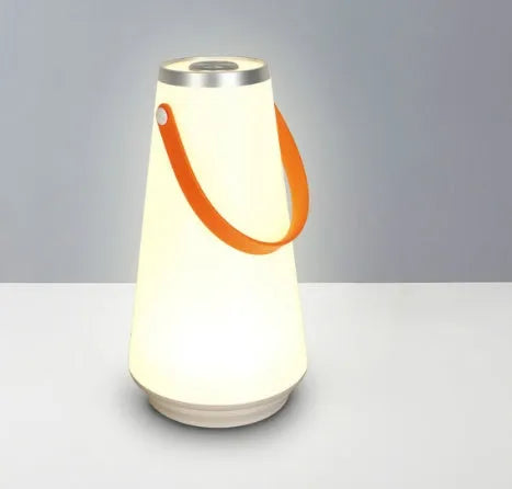 White rechargeable LED lantern night light with USB cable on a table