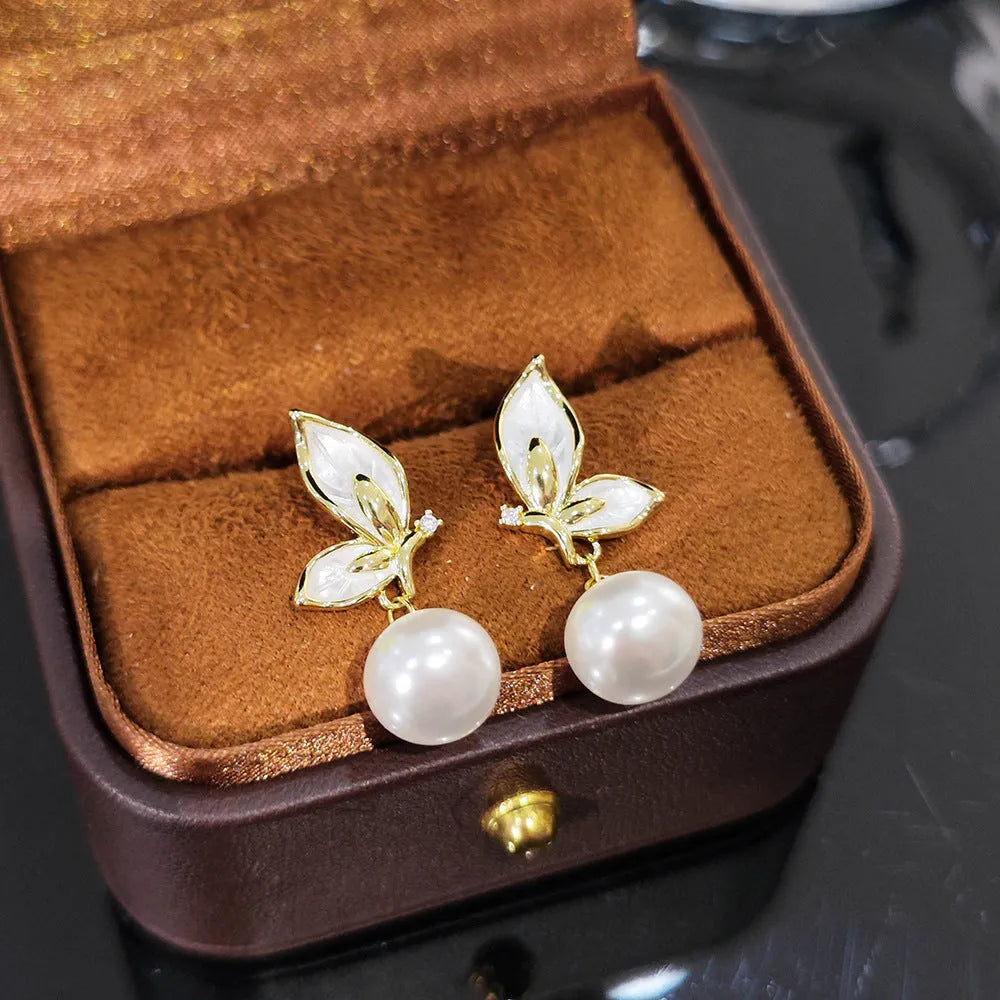 A pair of simple zircon butterfly stud earrings for women with copper electroplated finish.