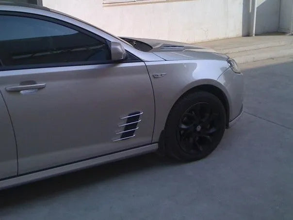 Black car body sticker with shark gill air outlet design and electroplated finish on a vehicle door