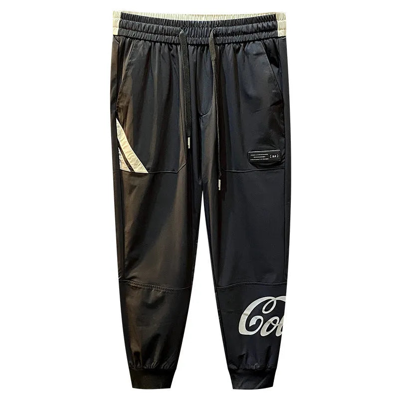 Men's solid black ultra-thin ice silk ankle-banded cropped casual trousers laid flat.