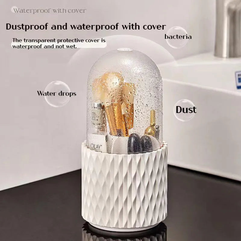 White acrylic rotating makeup brush holder with transparent body and a grey dust cover on a desk.