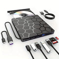 Black external USB CD DVD writer drive on a desk next to a laptop