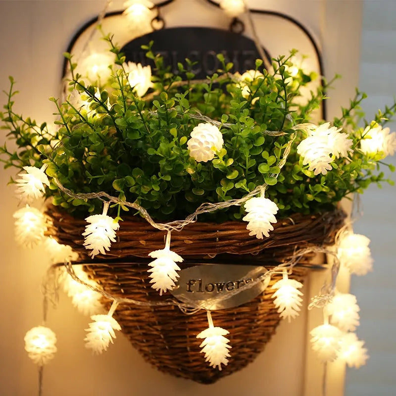 Warm white battery-powered LED pine cone lights on a string for festive decoration.