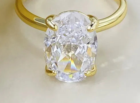 Oval sterling silver women's ring with four-claw setting and hand-cut gemstone.