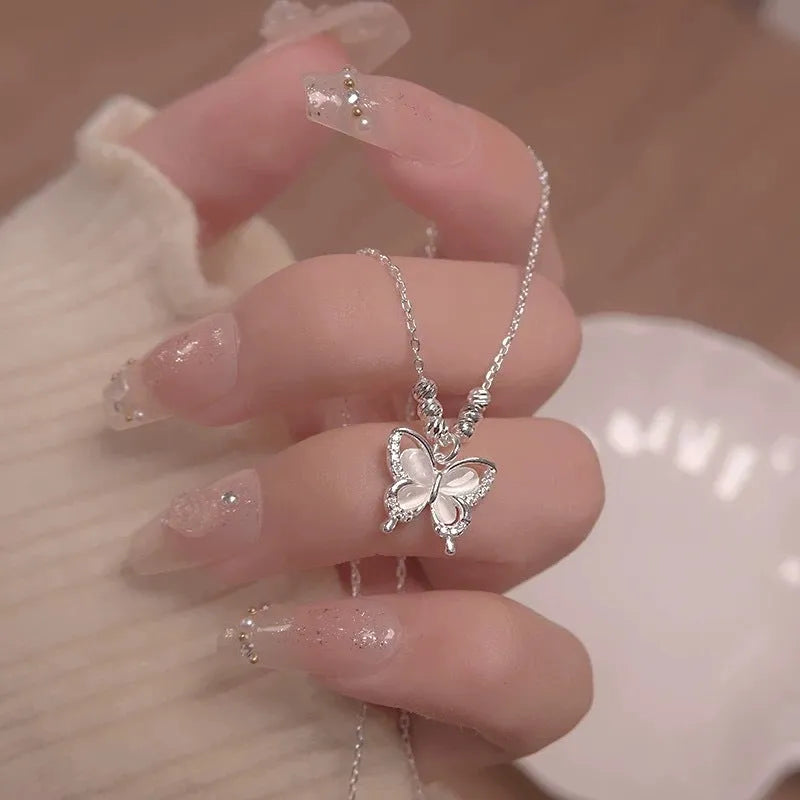 Silver butterfly pendant necklace with opal detail on cross chain