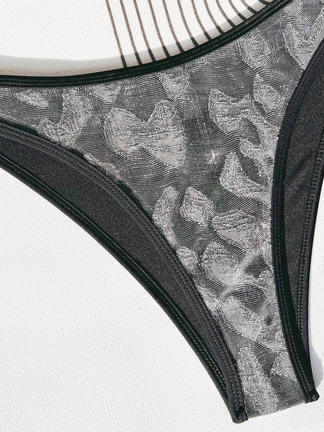 Black polyester ladies bikini set with straps, shown for swimming.