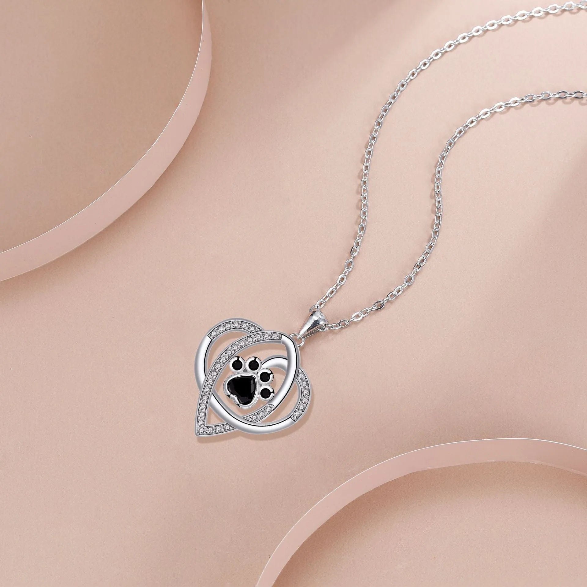 Silver tone necklace with cat and dog paw print pendant on cross chain for women