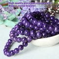 Natural transparent charoite crystal bracelet with platinum on a white background, showing bead detail.