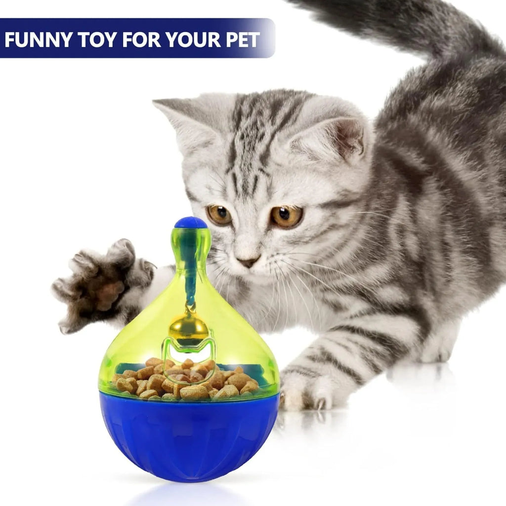 White tumbler-shaped dog and cat treat dispenser toy on a wooden floor