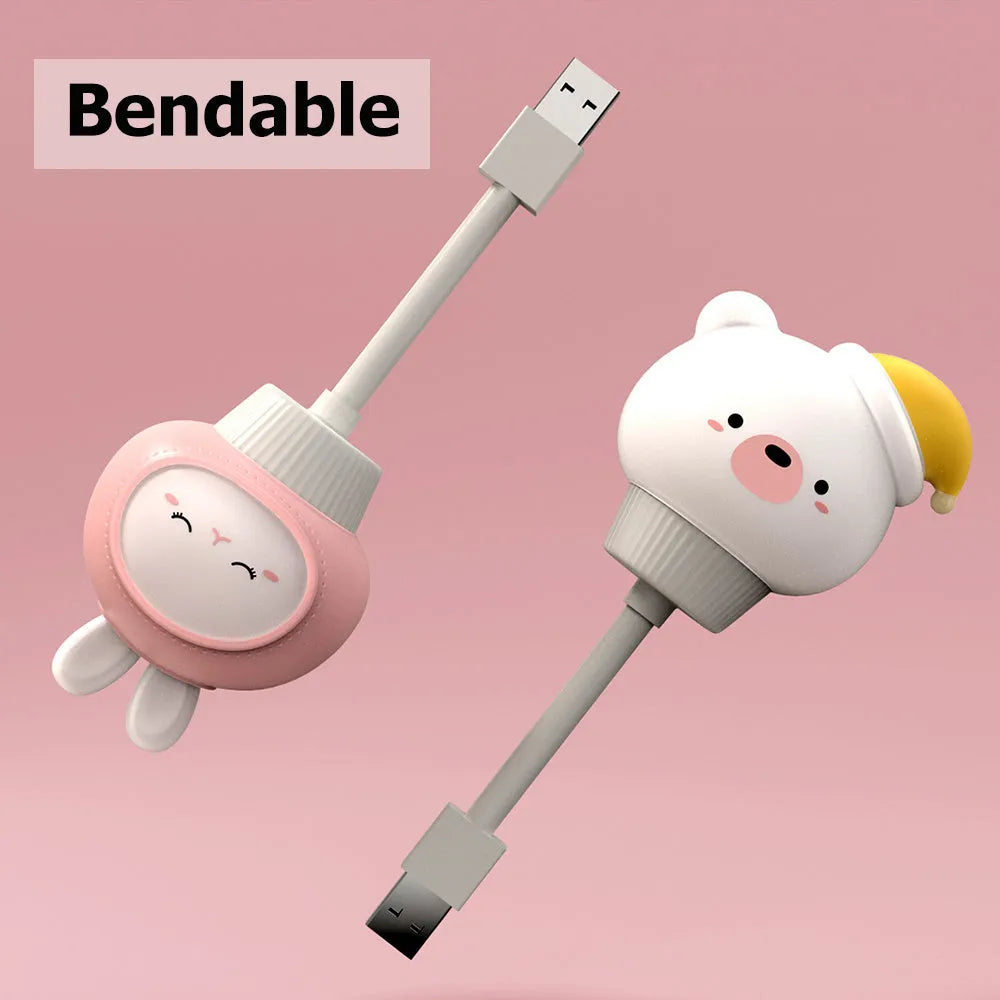 USB portable LED night light in cartoon bear shape with remote control on wooden table.