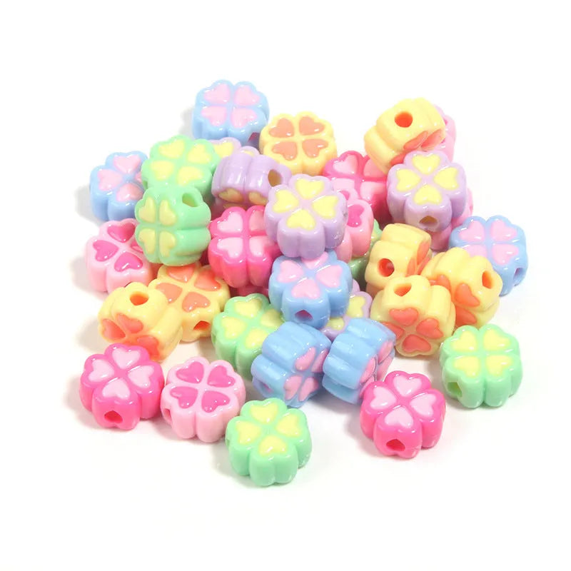 A selection of 15mm frosted acrylic beads in various colours, each showing a four-leaf clover love pattern.