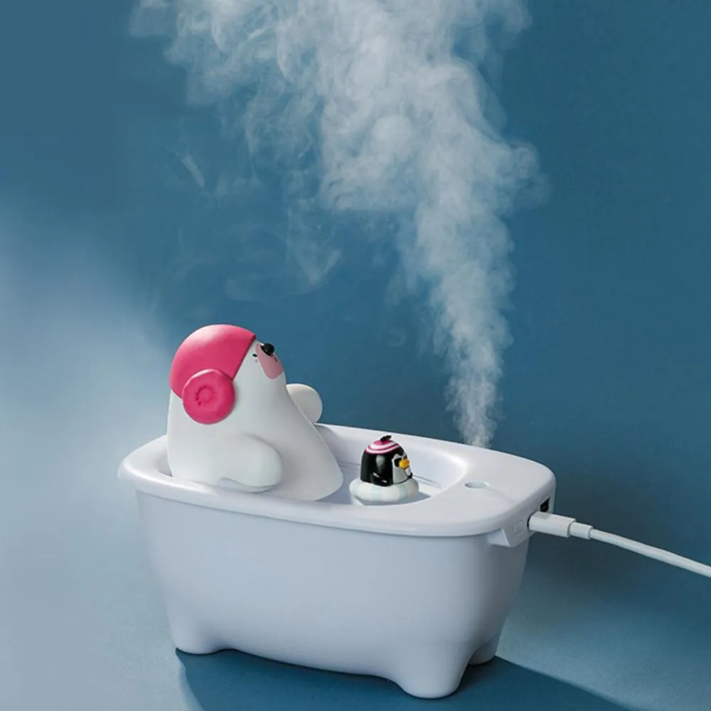 White USB air humidifier with large water tank on a desk next to a laptop.