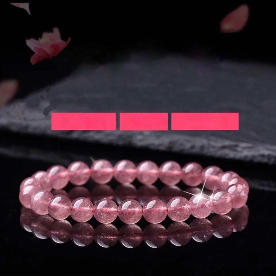 Women's bracelet with polished strawberry quartz crystal beads on an elastic cord, showing 6mm, 8mm and 10mm size options.