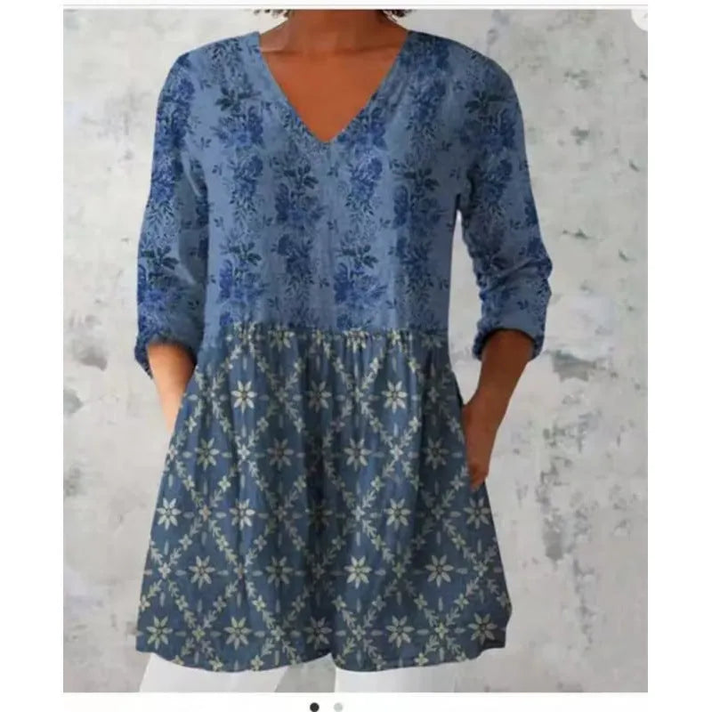 Printed women's loose dress with wide waist and three-quarter length sleeves on a hanger.