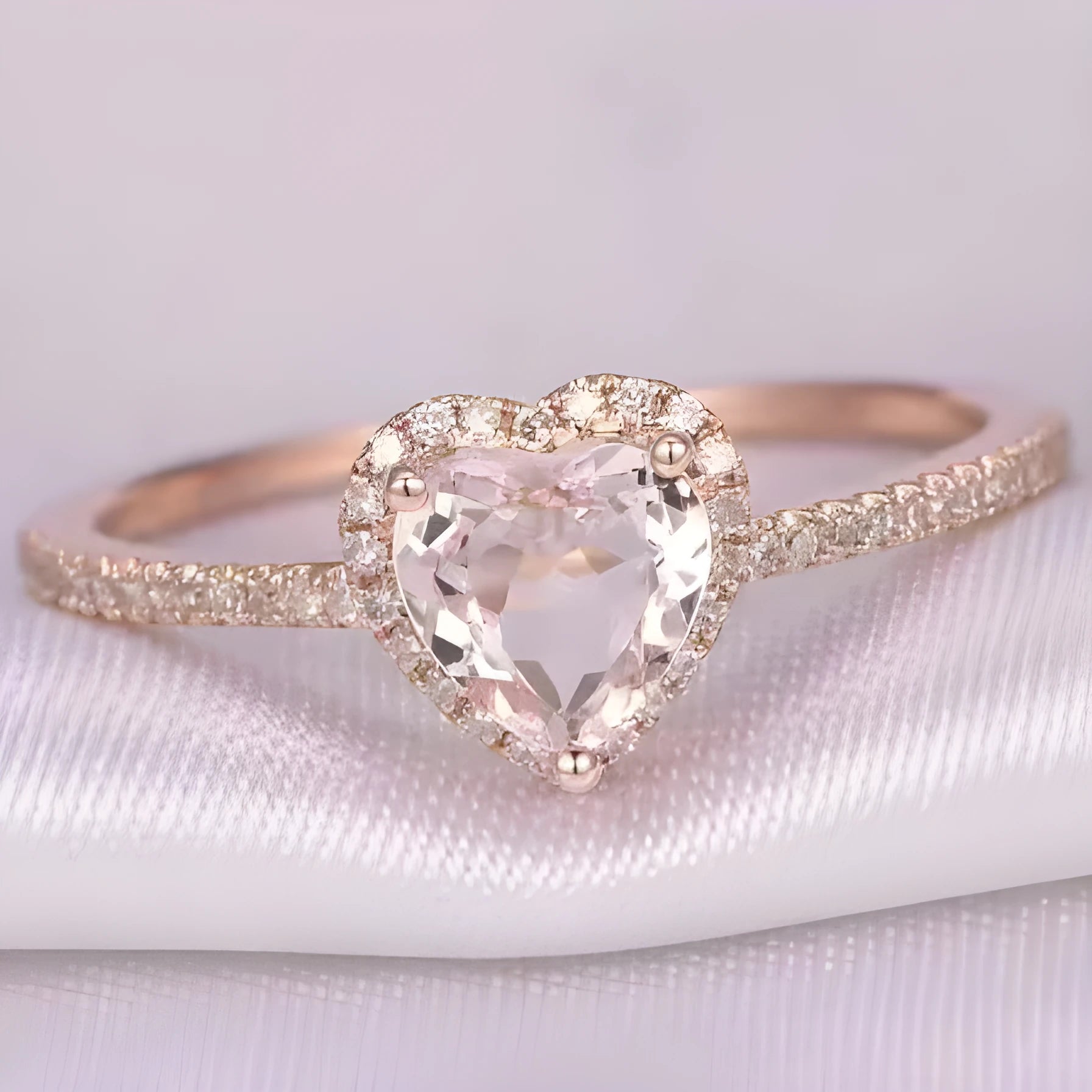 Heart-shaped crystal wedding ring in rose gold or silvery finish on white background