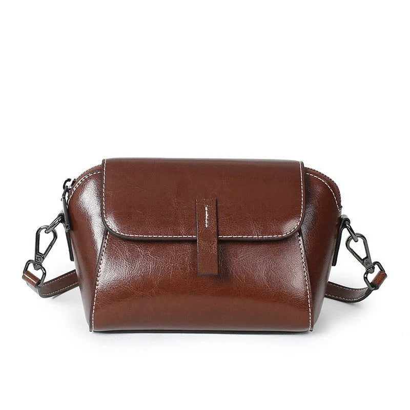 Brown women's crossbody messenger bag in soft oil wax leather with shell shape and visible sewing detailing