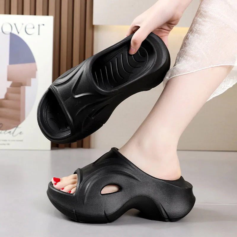 White women's EVA slippers with thick sole and round toe on a beach background.