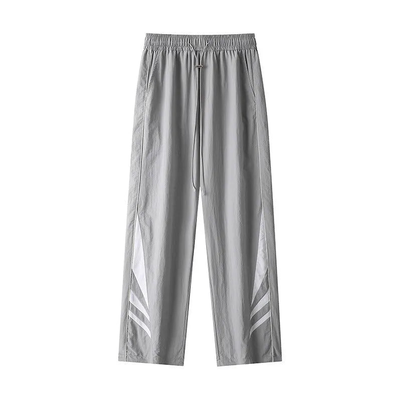 Man wearing straight leg grey casual trousers, showing the loose fit and mid-rise waist.
