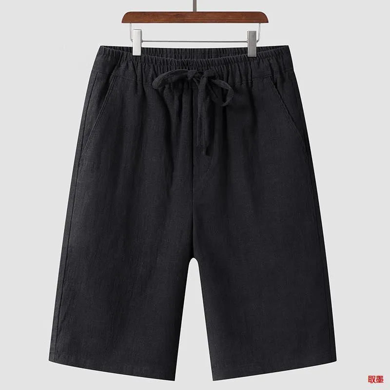 A pair of men's beige linen shorts with a loose, cropped cut and a mid-rise elasticated waistband.