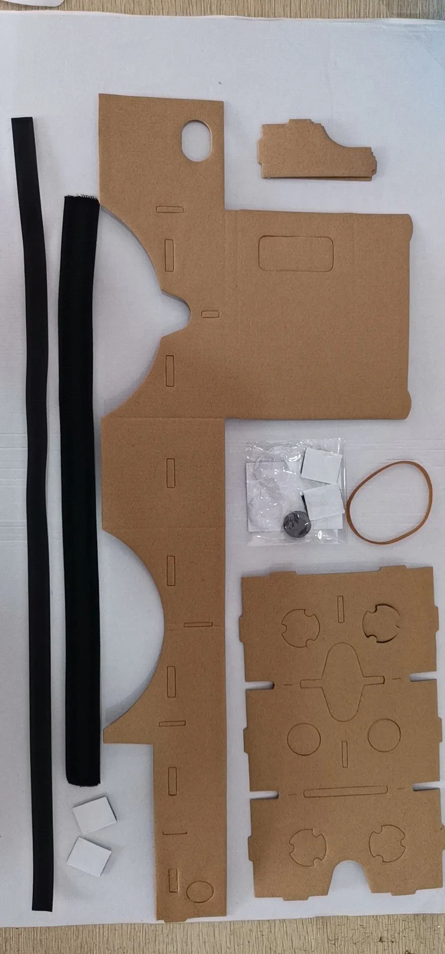 Pink and white cardboard VR glasses with rubber head strap and magnetic button for smartphones.