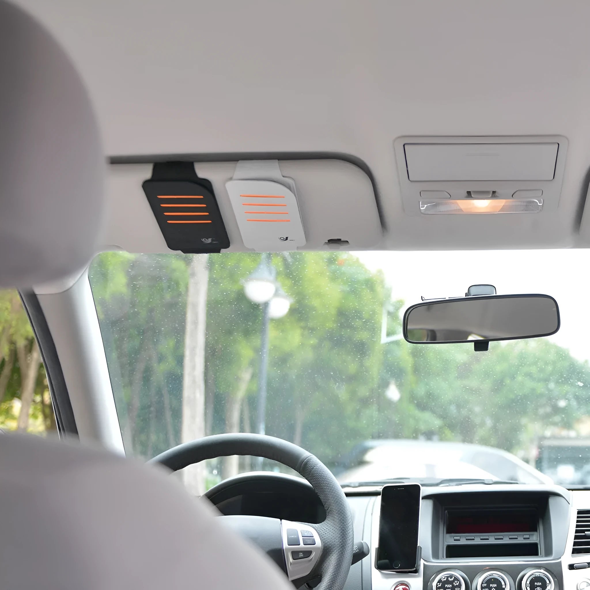 Car sun visor shading panels with storage bag showing four tablets for vehicle windscreen protection