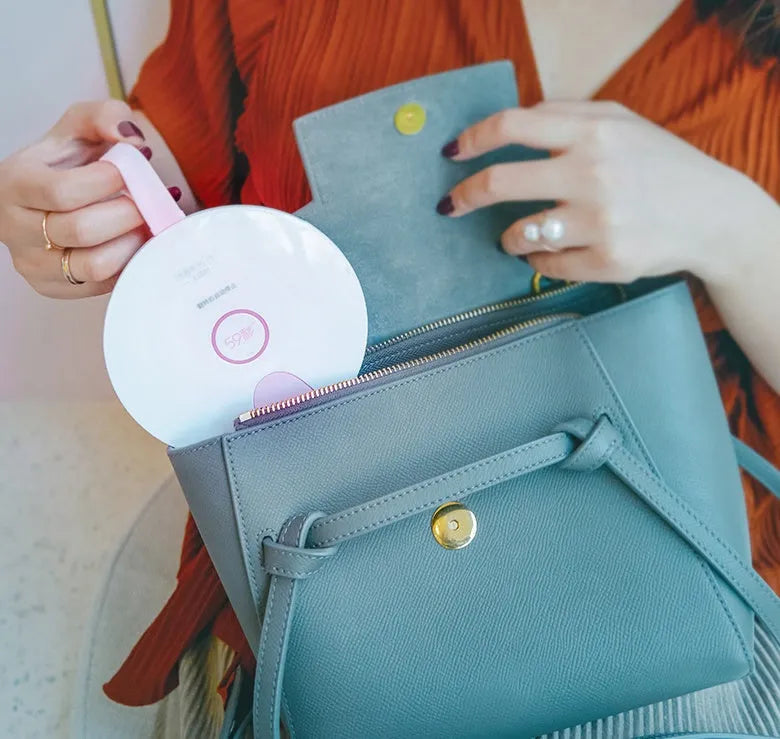A slim, portable baby bottle sterilizer in blue or pink, showing USB port and compact design.