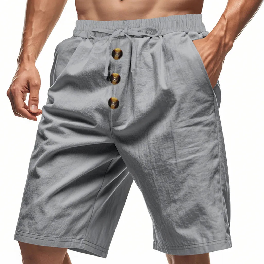 Men's loose straight polyester shorts in light khaki with elastic waist, side view on white background