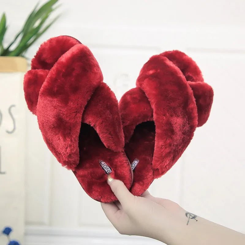 Cross-strap open-toe fur slippers in black with a textured sole, shown from the side.