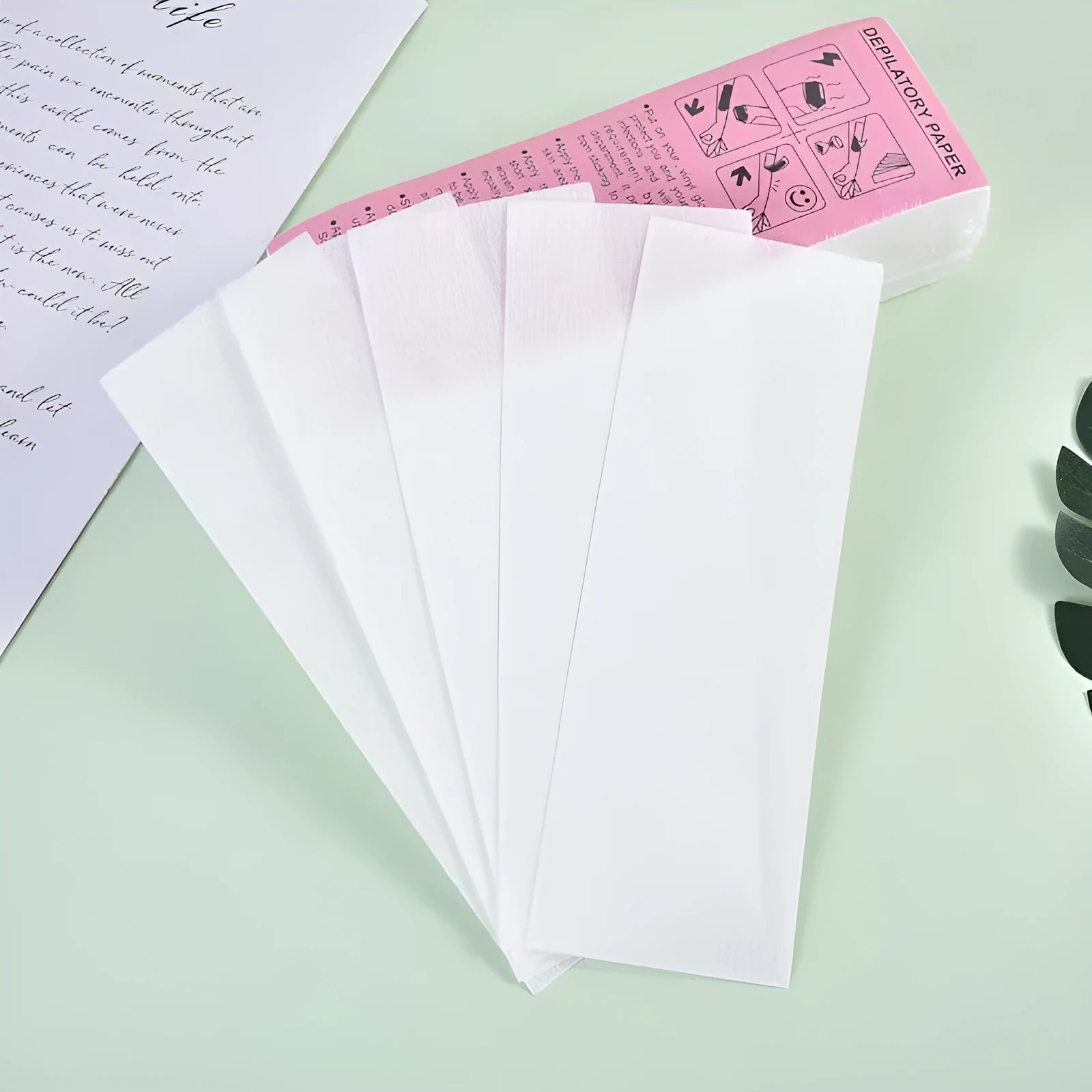 A pack of white non-woven fabric hair removal wax strips for body waxing.