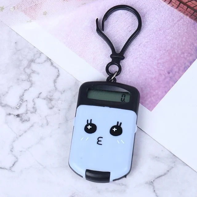 Creative cookie-shaped cute mini plastic calculator in black with key ring on a desk