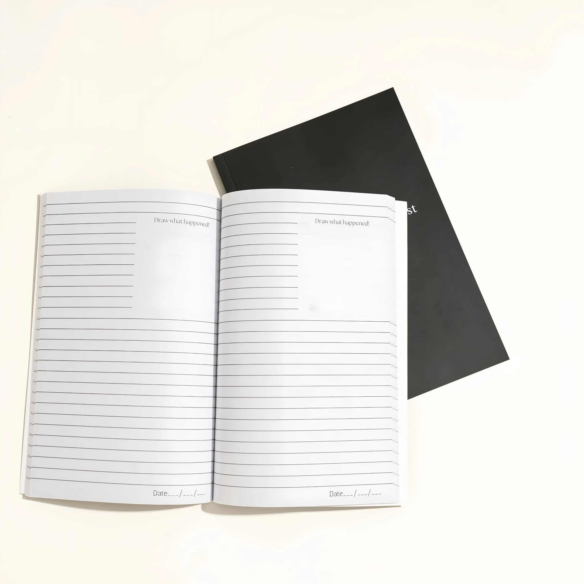Black hardcover dream journal notebook with minimalist design on a desk.
