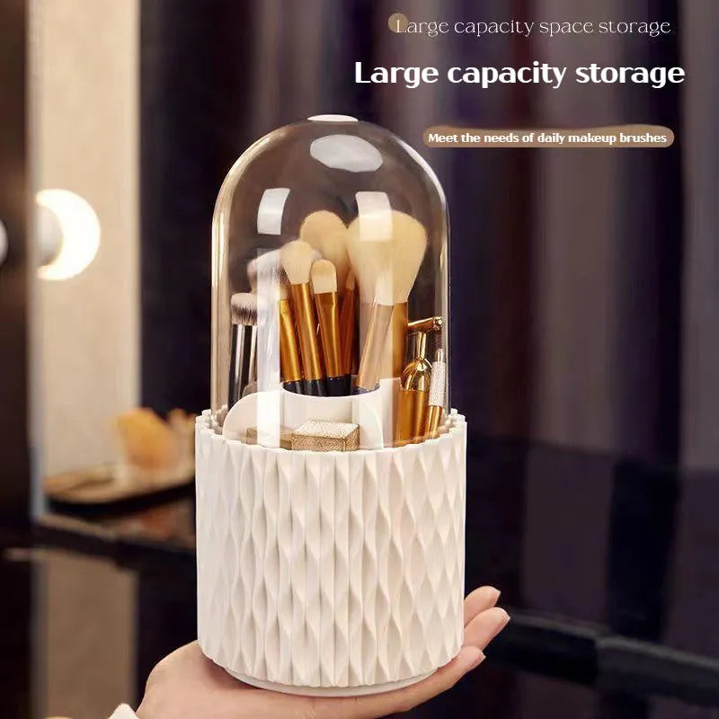 White acrylic rotating makeup brush holder with transparent body and a grey dust cover on a desk.
