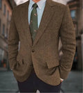 Man wearing a brown herringbone pattern retro suit jacket with a long sleeve cut.