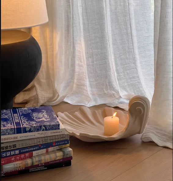 White resin shell-shaped fruit plate ornament with light luxury styling on a table.