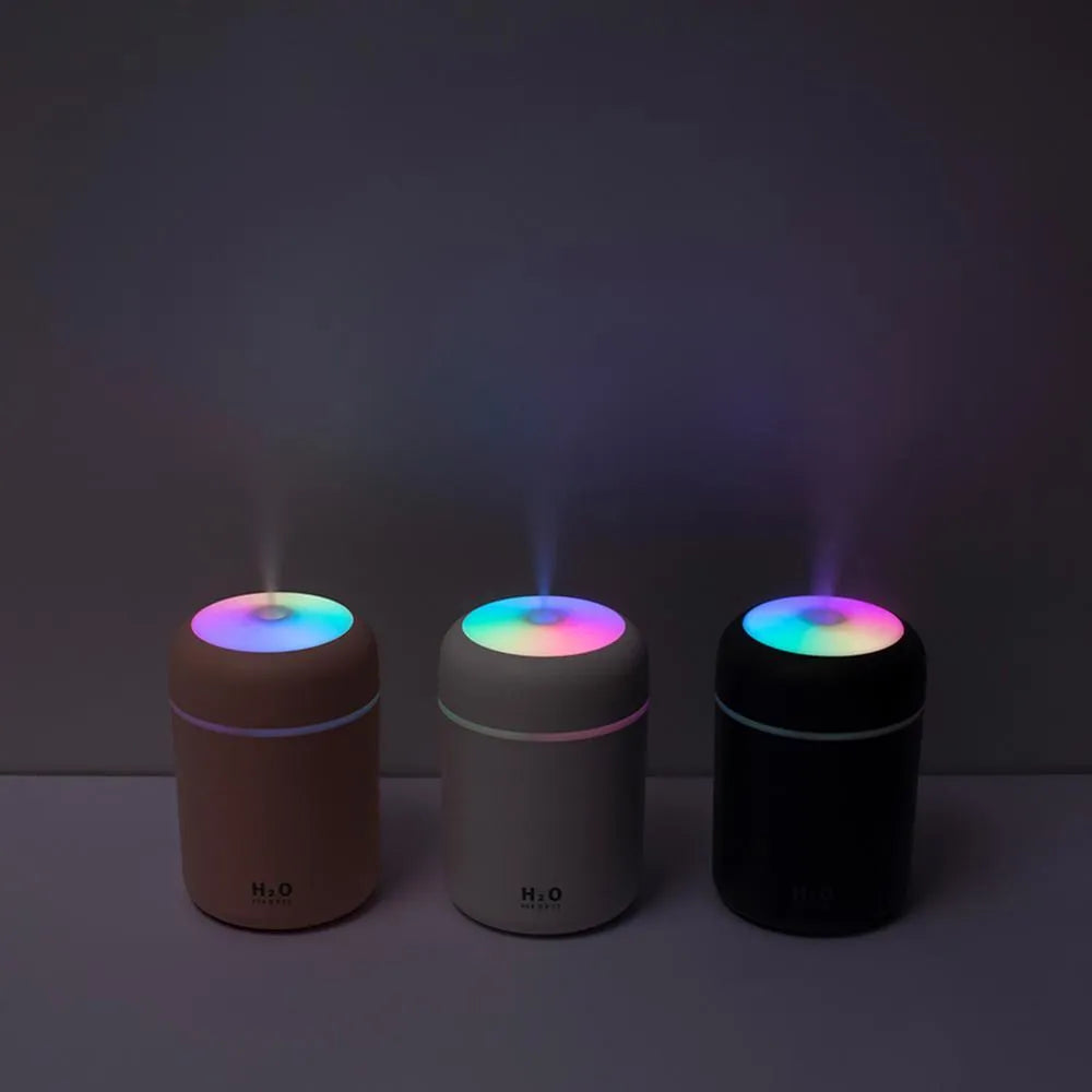 USB mini humidifier with colourful lights in pink, white, or navy blue colours on a desk