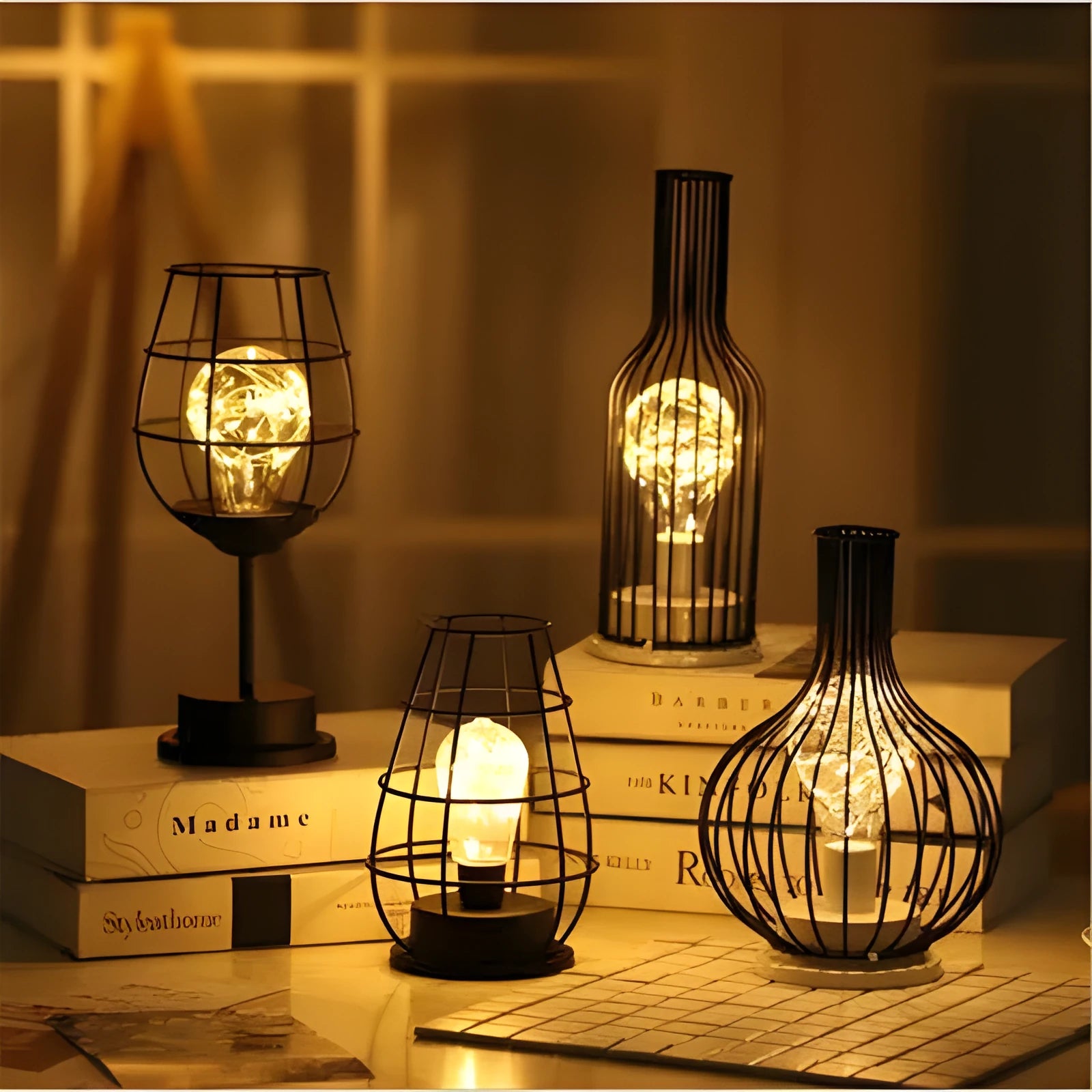 Minimalist hollow wrought iron table lamp in red wine bottle style on a wooden desk.
