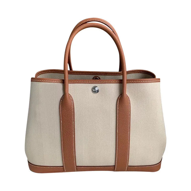 Women's canvas crossbody bucket tote bag with genuine leather trim showing internal organisation pockets