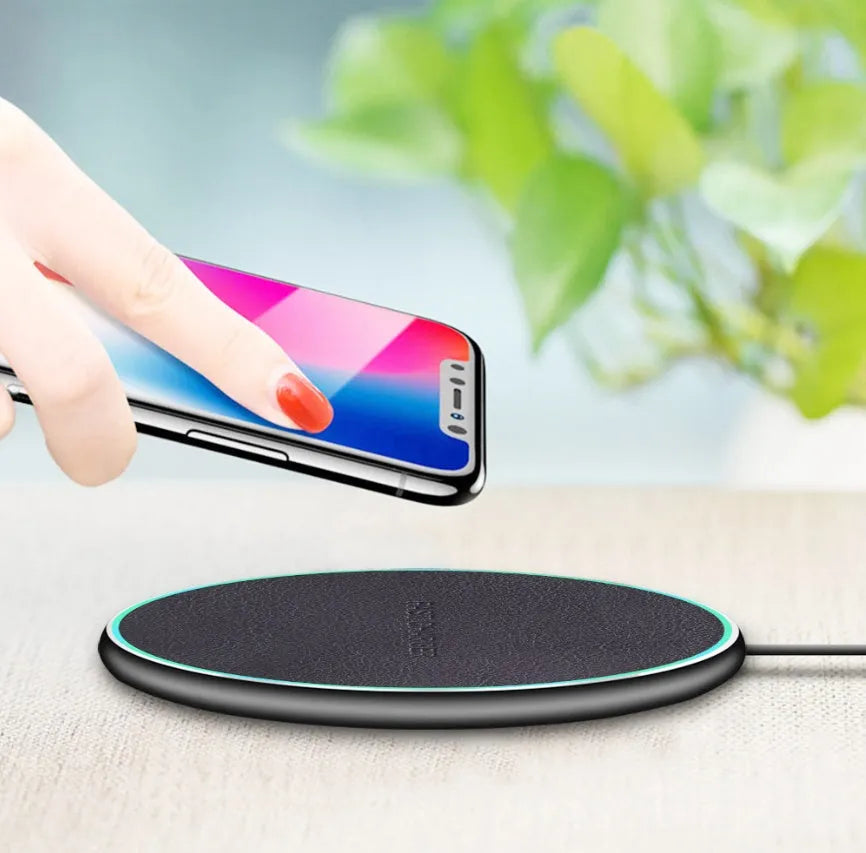 Black circular Qi wireless charging pad for iPhone 11 with non-slip surface