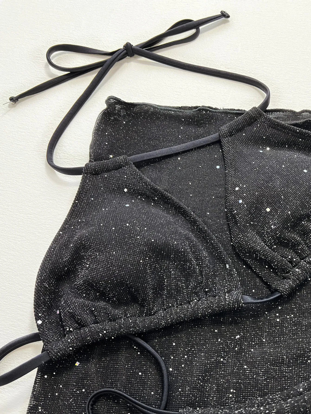 Black three-piece polyester bikini set with top and shorts on a size chart showing S, M, L.