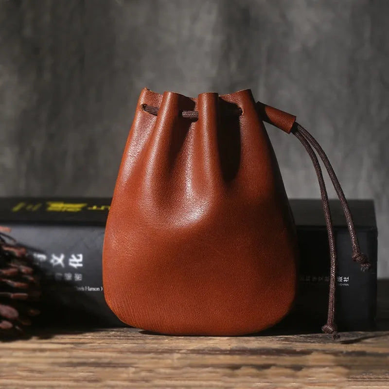 Vintage style cowhide leather drawstring bundle wallet in black, showing sewing thread detail and drawstring closure.