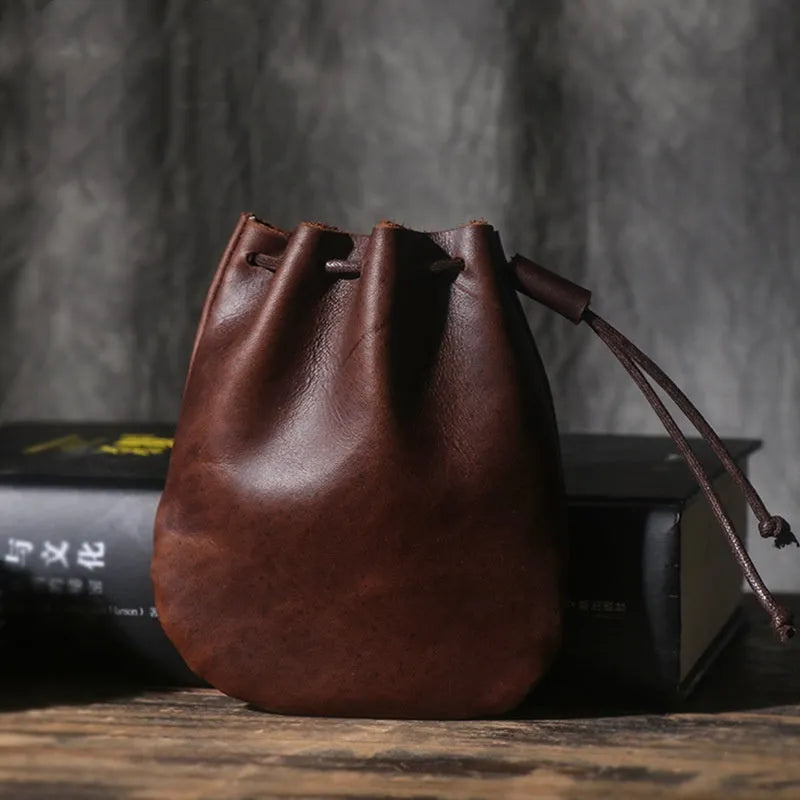 Vintage style cowhide leather drawstring bundle wallet in black, showing sewing thread detail and drawstring closure.