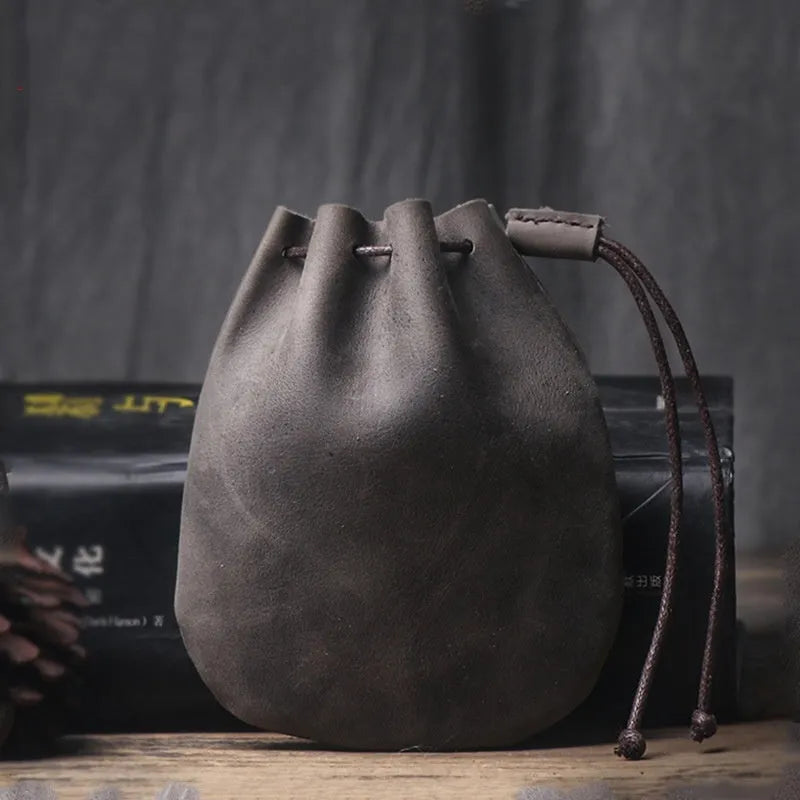 Vintage style cowhide leather drawstring bundle wallet in black, showing sewing thread detail and drawstring closure.