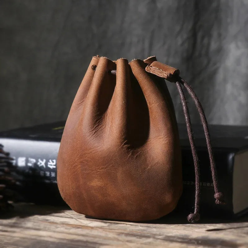 Vintage style cowhide leather drawstring bundle wallet in black, showing sewing thread detail and drawstring closure.