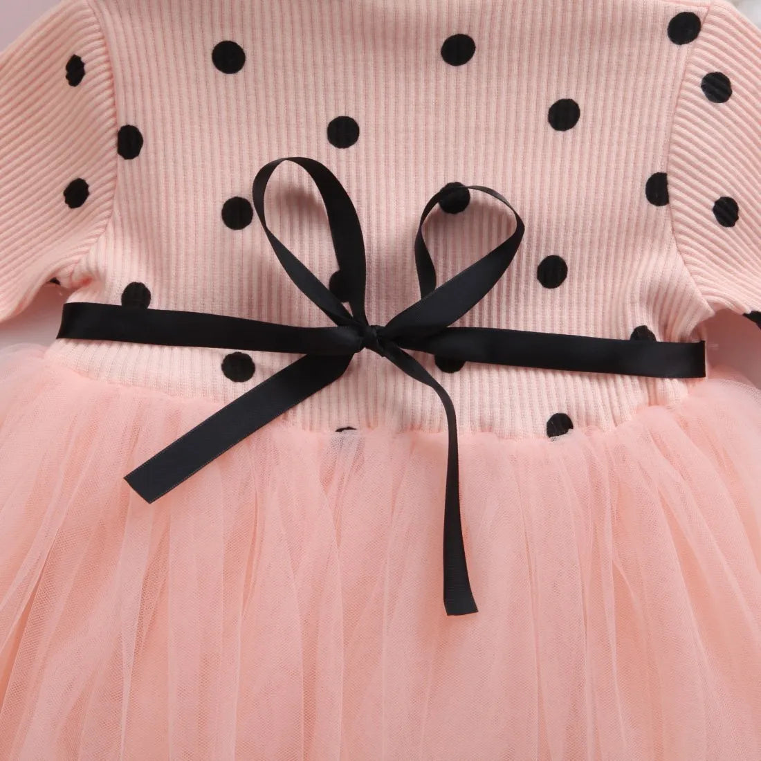 Baby girl in a long sleeve black tutu lace dress for a birthday party.