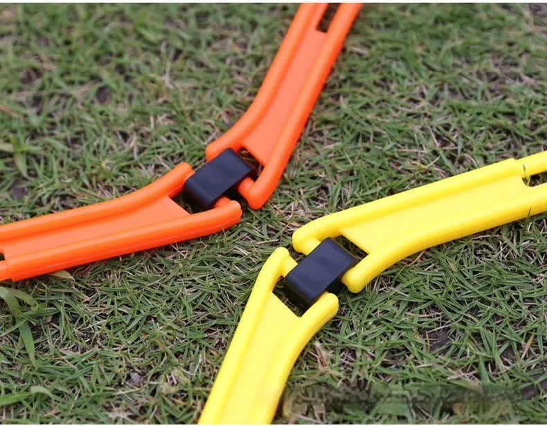 Six foldable hexagon agility training rings in green, orange, and yellow colours laid out on grass.