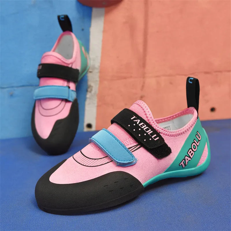 Beginner rock climbing shoes with Velcro strap and rubber sole in black and red colour.